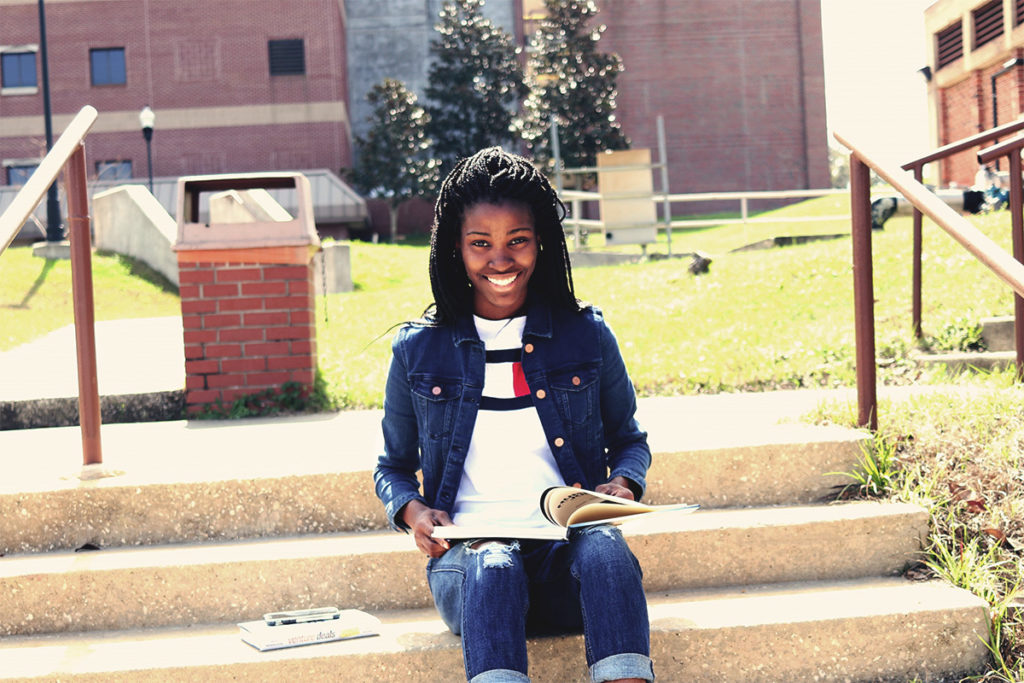 Young black woman studying and smiling.