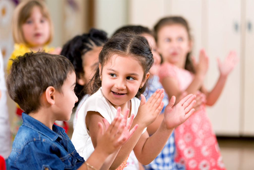 Preschool children clapping.