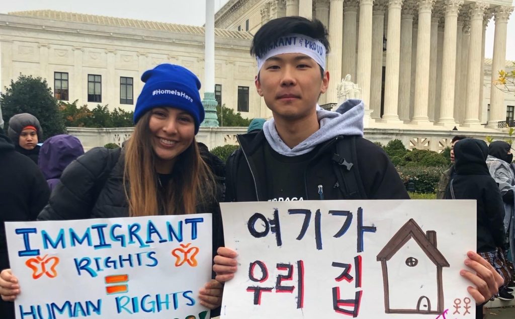Valery Martinez and Jang Lee holding signs outside of the US Supreme Court for the DACA march.