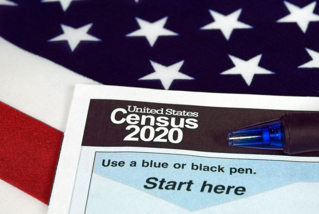United States Census 2020 paperwork lying on an American flag.