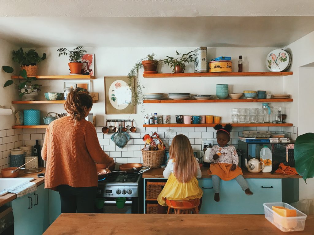 Woman and two young girls in the kitchen.