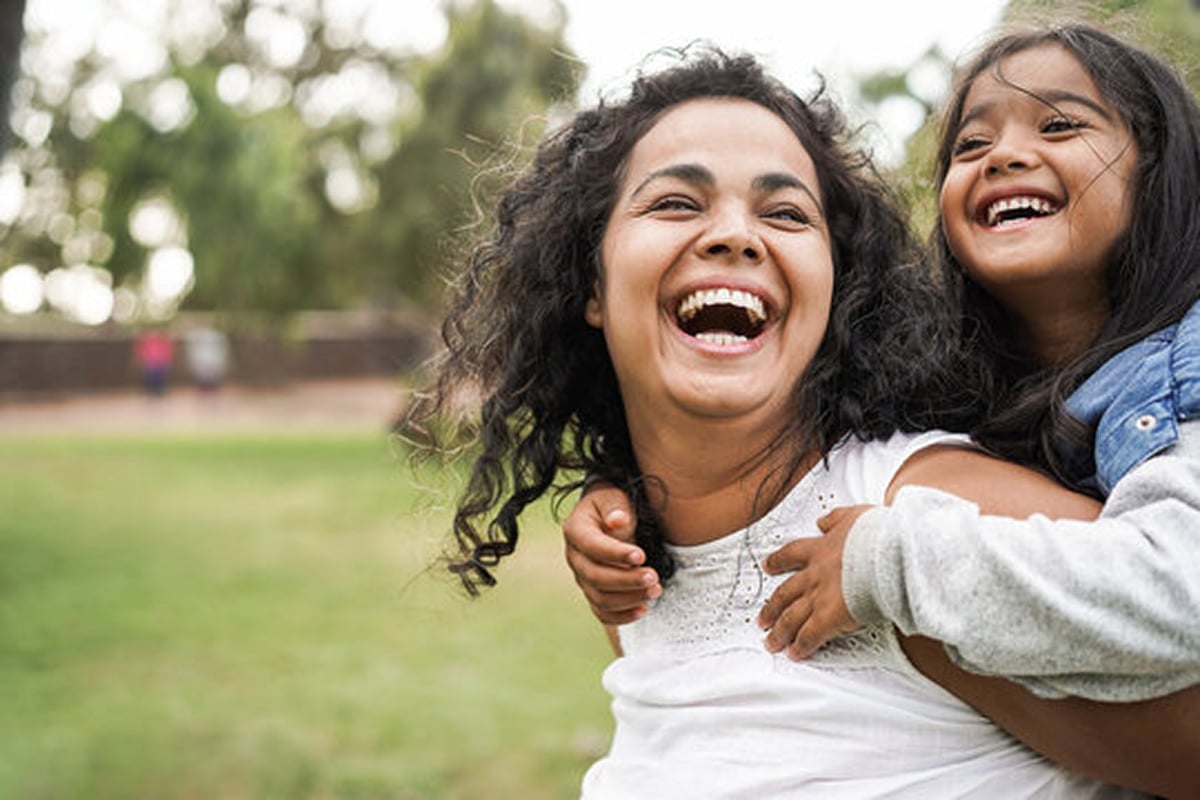 Happy indian mother having fun with her daughter outdoor.