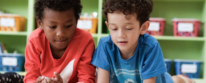 Two preschool boys reading together.