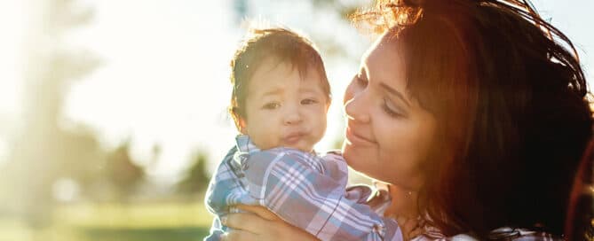 Youth parent smiling at her infant son.