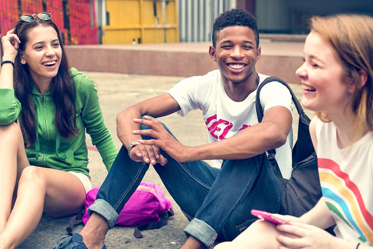 Diverse teens laughing together.