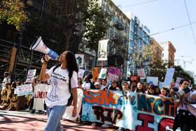 Young black woman with a megaphone leading a march.