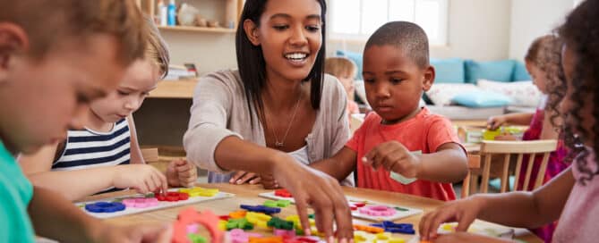 Preschool teacher playing with students.