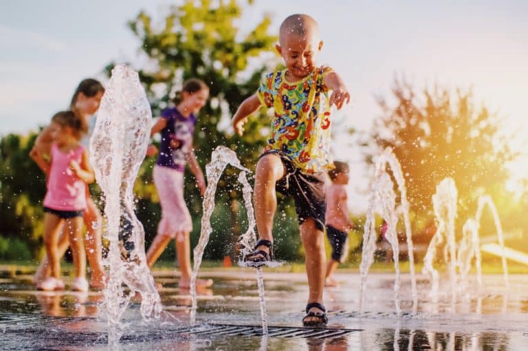 Processed with VSCO with au5 preset Boy playing in a fountain with friends.