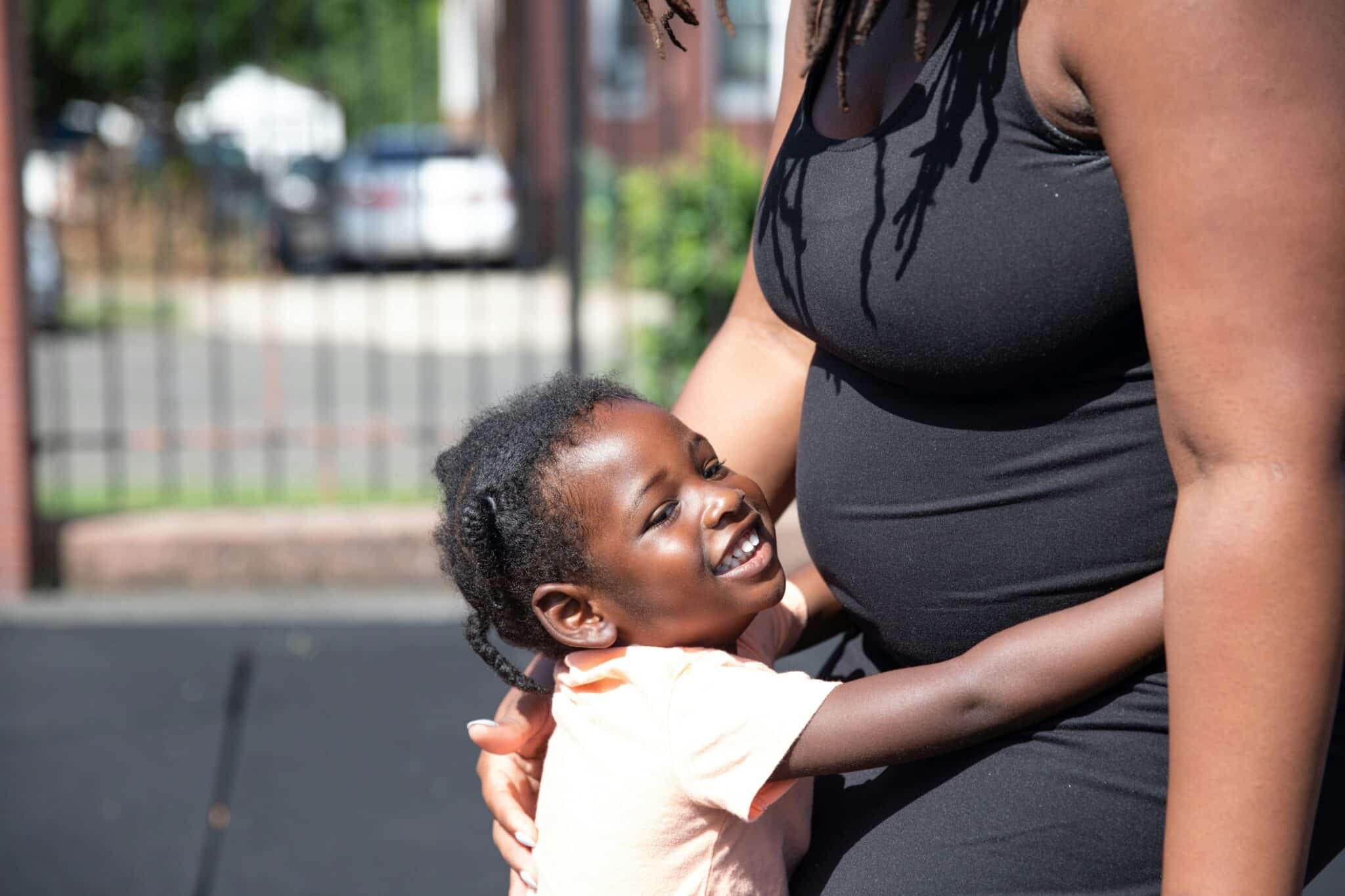 A toddler hugs their mom