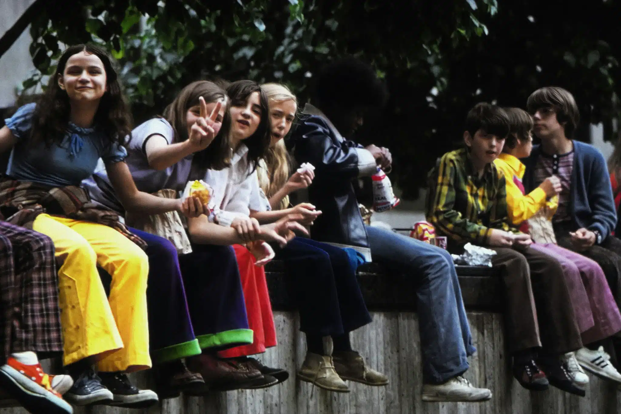 a group of kids eating a snack outside