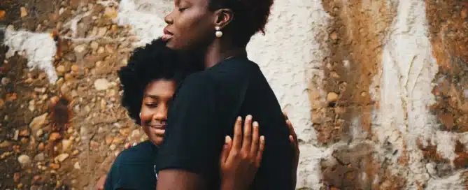 A young teenager embracing a woman