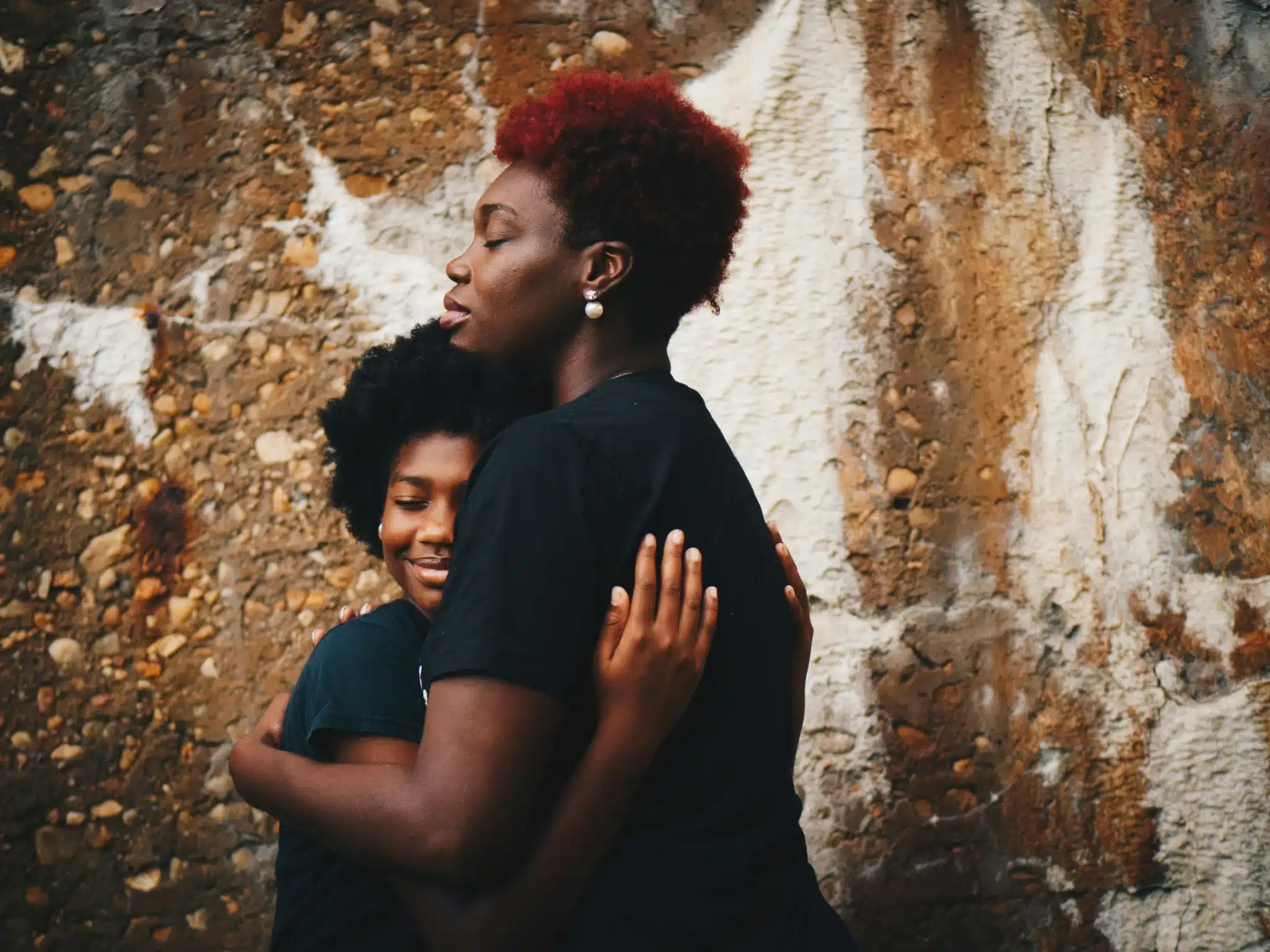 A young teenager embracing a woman